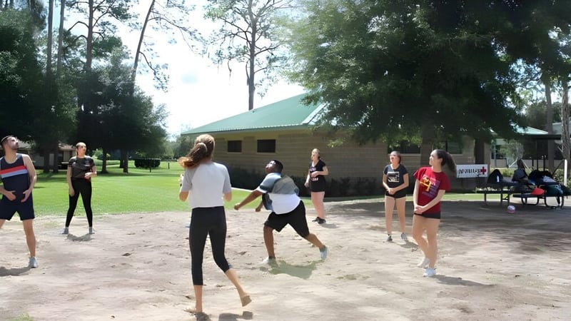 Schüler der Miami Arts Charter School führen eine körperliche Aktivität im Außenbereich near einer Holzkonstruktion durch.