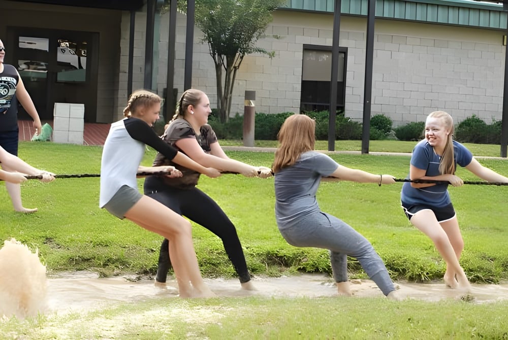 Schüler der Miami Arts Charter School stehen auf einer Wiese vor einem Gebäude und machen gemeinsam körperliche Übungen.