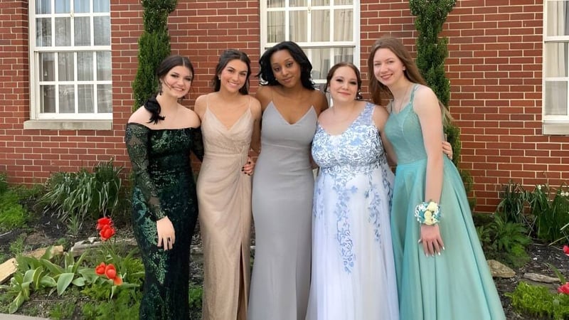 Eine Gruppe von fünf Schülerinnen der Middletown Christian School steht vor einem Backsteingebäude mit grünem Hintergrund.