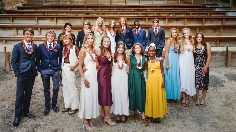 Eine Gruppe Schülerinnen und Schüler der Midland School steht auf Steintreppen vor einem Backsteingebäude.