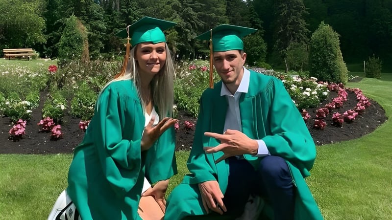 Zwei Schüler in grünen Abschlusskleidern stehen im Garten auf dem Campus der Miles Macdonell Collegiate.