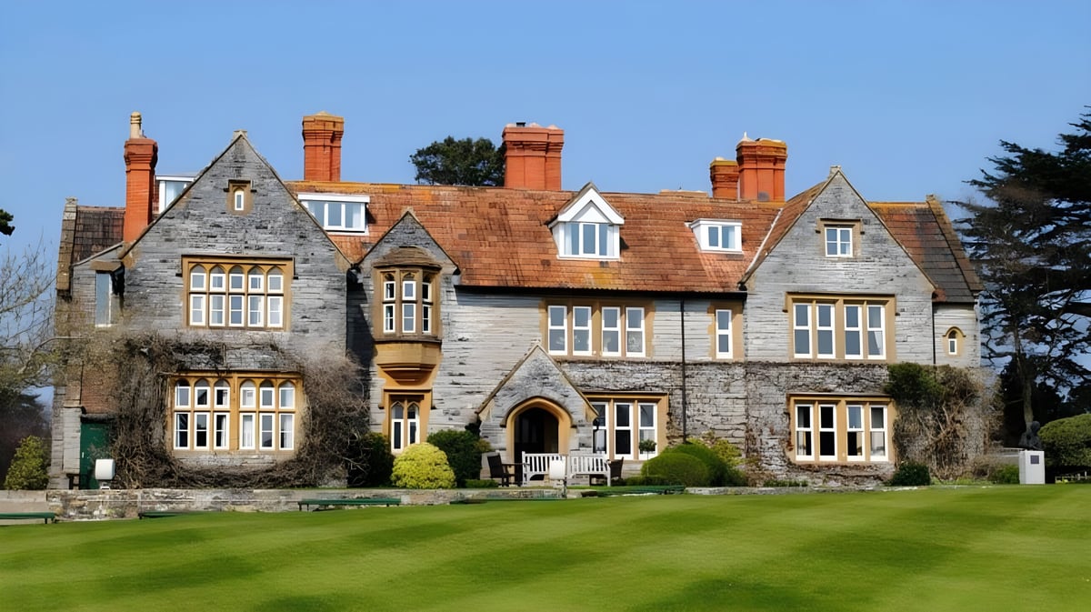 Das historische Herrenhaus auf dem Campus der Millfield School ist von gepflegtem Rasen und üppigem Grün umgeben.