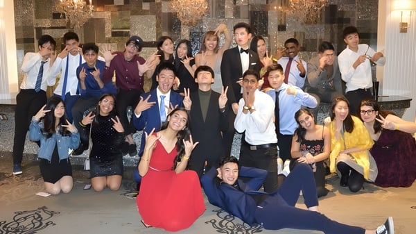 Eine Gruppe von Menschen in formeller Kleidung versammelt sich in einem prunkvollen Raum auf dem Campus der Milliken Mills Secondary School.