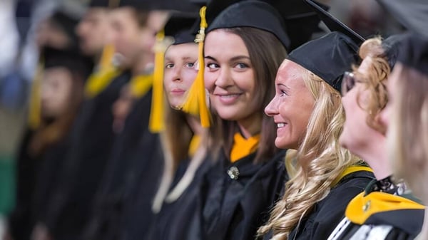 Absolventen der Milton Abbey School feiern gemeinsam ihren Abschluss in schwarzen Talaren und Hüten.