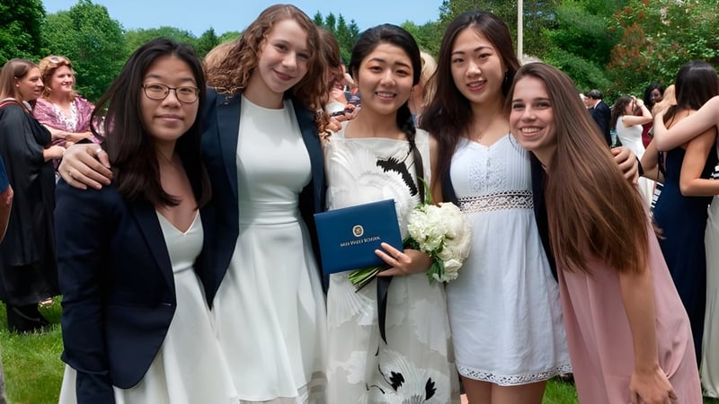 Eine Gruppe junger Frauen steht gemeinsam im grünen Außenbereich auf dem Campus der Miss Hall’s School.