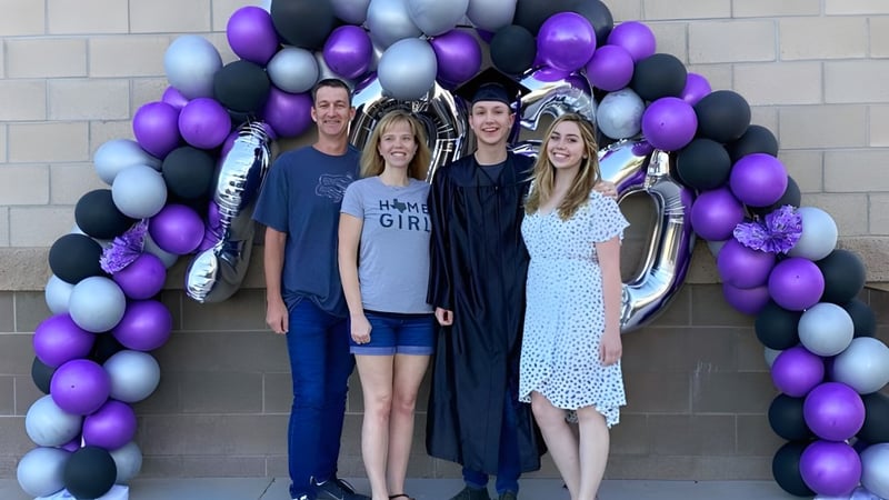 Fünf Personen stehen vor einem bunten Ballonbogen auf dem Campus der Mission Heights Preparatory High School und feiern ein Ereignis.