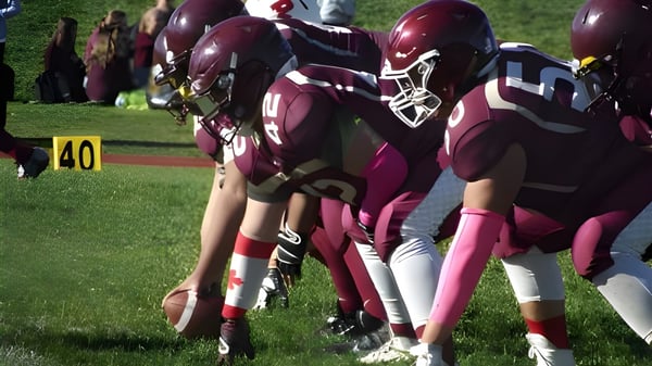 Eine Gruppe Footballspieler in den Farben der M.M. Robinson High School steht auf einem Fußballfeld mit Markierungen.
