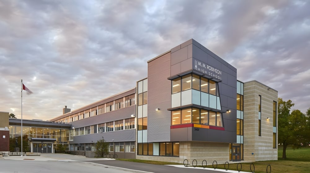 Das moderne mehrstöckige Gebäude mit Glas- und Betonfassaden der M.M. Robinson High School vor bewölktem Himmel.