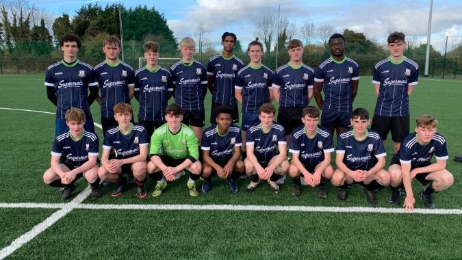 Eine Gruppe junger Fußballspieler posiert gemeinsam auf dem Spielfeld des Moate Community College.