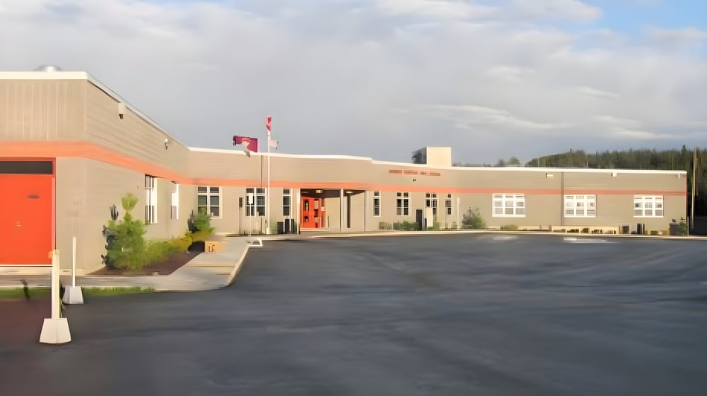 Das moderne mehrstöckige Gebäude mit roter Eingangstür und kanadischer Flagge der Mobile Central High ist zu sehen.