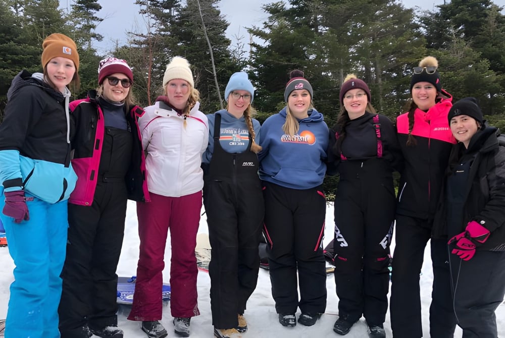 Eine Gruppe Schüler der Mobile Central High steht in winterlicher Kleidung in einem verschneiten Wald.