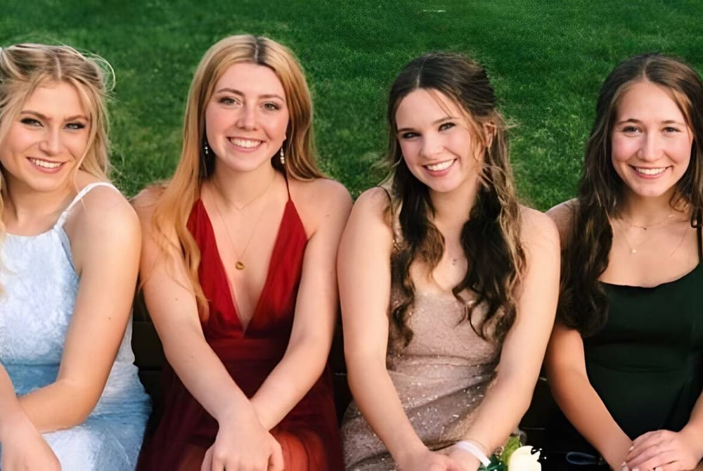 Vier Schülerinnen der Monarch High School posieren gemeinsam auf einer grasbewachsenen Wiese.