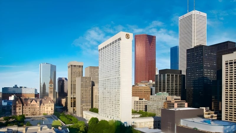 Eine lebendige Stadtsilhouette mit hohen Wolkenkratzern vor blauem Himmel nahe dem Monarch Park Collegiate Institute.