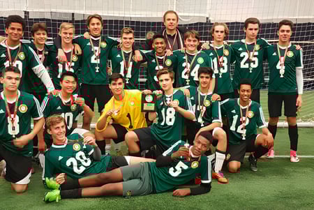 Schüler des Monarch Park Collegiate Institute posieren gemeinsam auf dem Fußballfeld vor dem Tor.