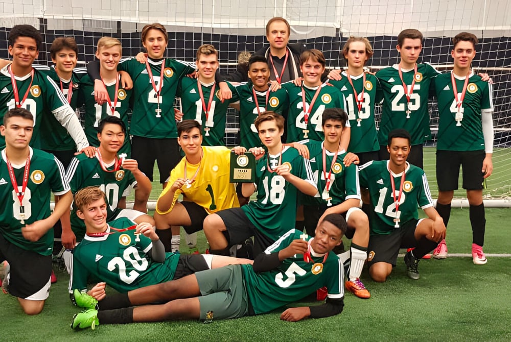Schüler des Monarch Park Collegiate Institute posieren gemeinsam auf dem Fußballfeld vor dem Tor.