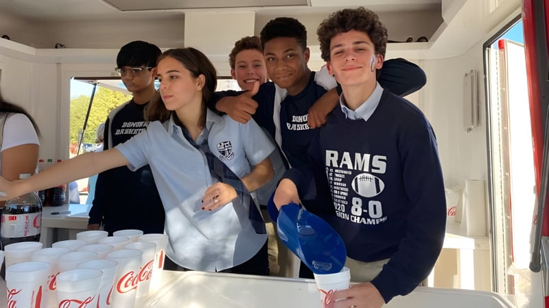 Eine Gruppe von Schülerinnen und Schülern der Monsignor Donovan Catholic High School posiert gemeinsam in einer Küchenumgebung.