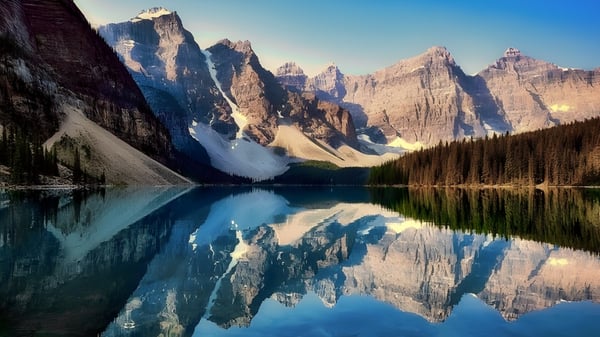 Ein ruhiger alpiner See mit schneebedeckten Bergen, die sich im Wasser spiegeln, nahe der Montague Regional High School.