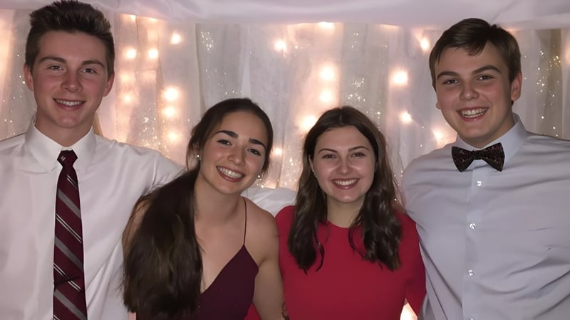 Vier Schüler der Montague Regional High School posieren lächelnd gemeinsam in festlicher Umgebung mit funkelnden Lichtern.