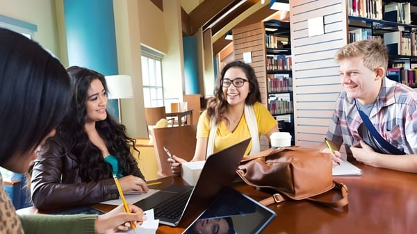 Eine Gruppe Schülerinnen und Schüler der Montcalm Secondary School arbeitet gemeinsam mit Laptops in einem Studienbereich.