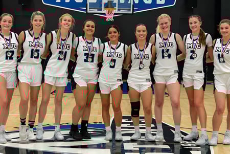 Eine Gruppe junger Basketballspielerinnen steht auf dem Basketballfeld der Monte Vista Christian School.