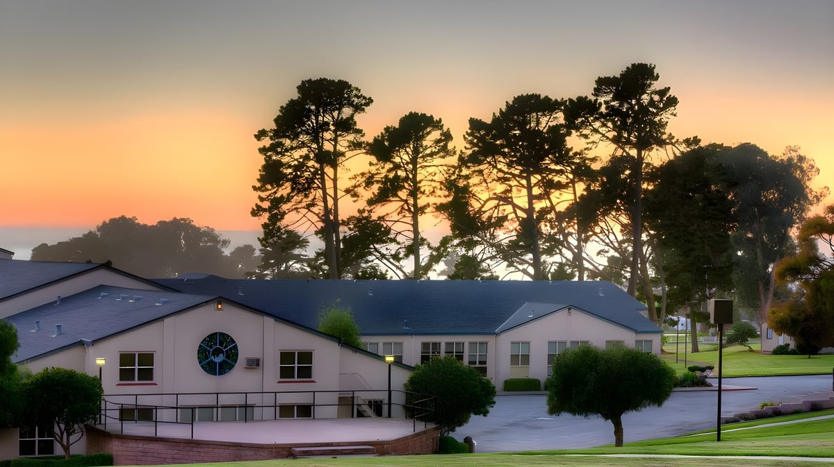 Das Wohnviertel mit hohen Kiefern vor dem farbenfrohen Sonnenuntergang auf dem Campus der Monterey Bay Academy.