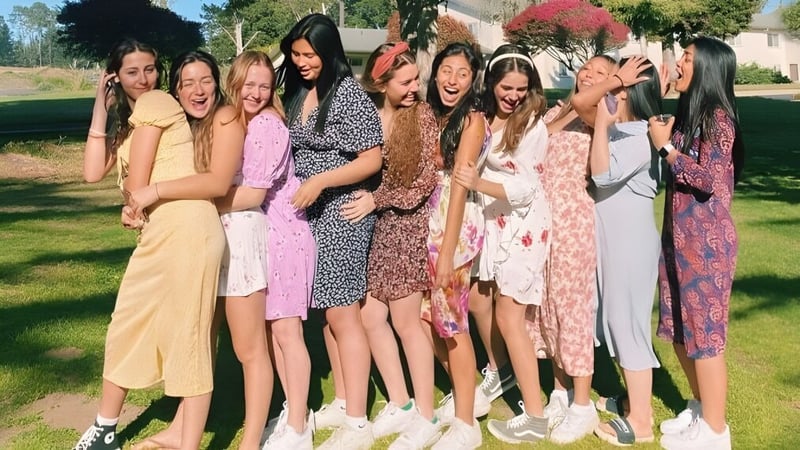 Eine Gruppe Schülerinnen der Monterey Bay Academy steht im Freien auf einer Wiese und umarmt sich.