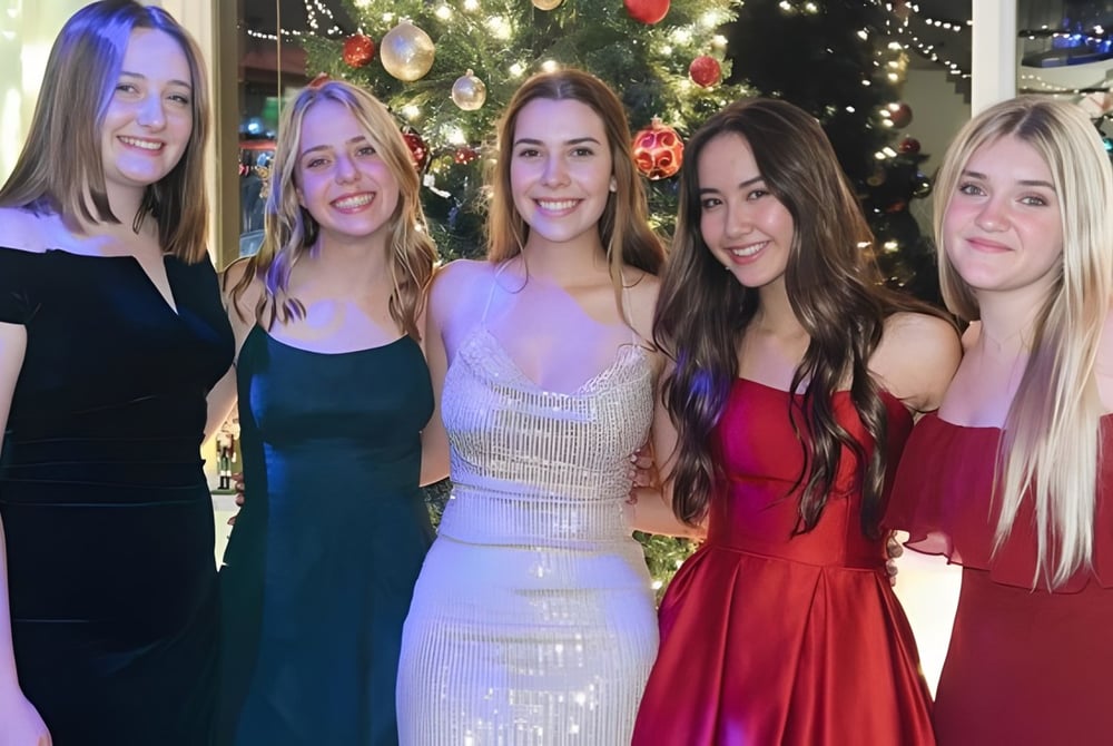 Fünf Schülerinnen der Monterey Bay Academy posieren gemeinsam vor einem festlich geschmückten Weihnachtsbaum.