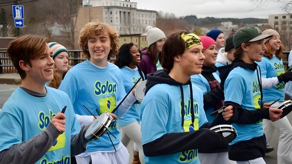 Schüler des Montpelier Roxbury Public School District tragen einheitliche blaue Solar-Shirts in einem urbanen Umfeld.