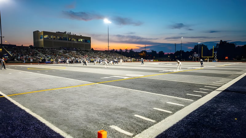 Das Footballfeld der Morgan High School ist bei Sonnenuntergang mit Zuschauern im Stadium zu sehen.