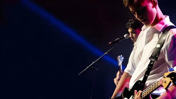 Eine Person in weißem Hemd und dunkler Hose tritt auf der Bühne auf dem Campus der Mount Albert Grammar School auf.
