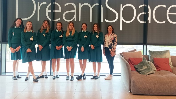 Eine Gruppe junger Frauen in grünen Uniformen steht vor dem Dreamspace-Schild auf dem Campus der Mount Anville Secondary School.