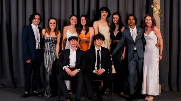 Eine Gruppe von Personen posiert vor einem dunklen Vorhang auf dem Campus des Mount Aspiring College.