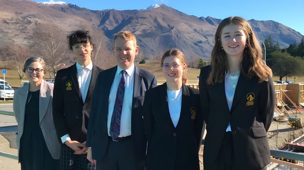 Fünf Schüler stehen vor einer Berglandschaft auf dem Gelände des Mount Aspiring College.
