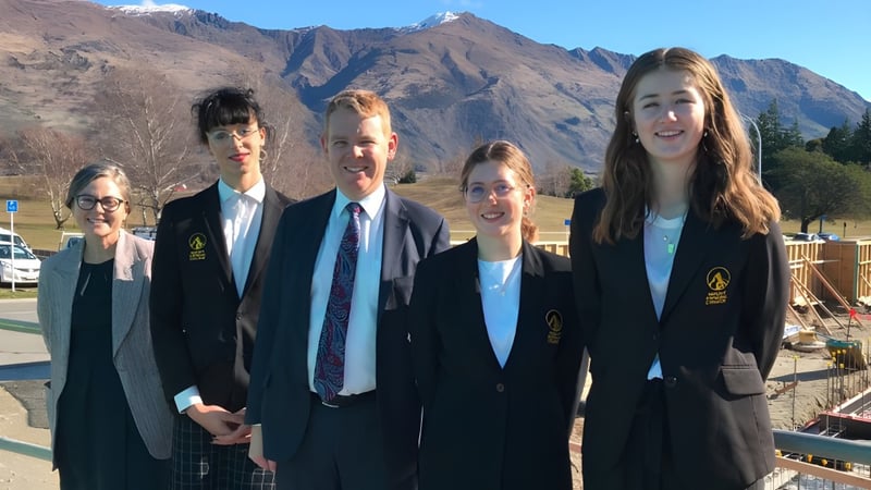 Fünf Schüler stehen vor einer Berglandschaft auf dem Gelände des Mount Aspiring College.