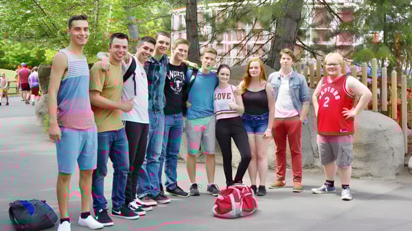 Eine Gruppe Schüler steht auf der Straße vor Gebäuden und Bäumen auf dem Campus der Mount Baker Secondary School.