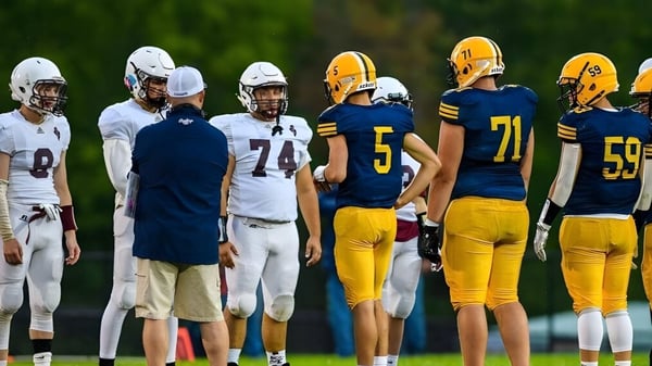 Eine Gruppe von Fußballspielern steht gemeinsam auf einem Spielfeld der Mount Blue High School im Freien.