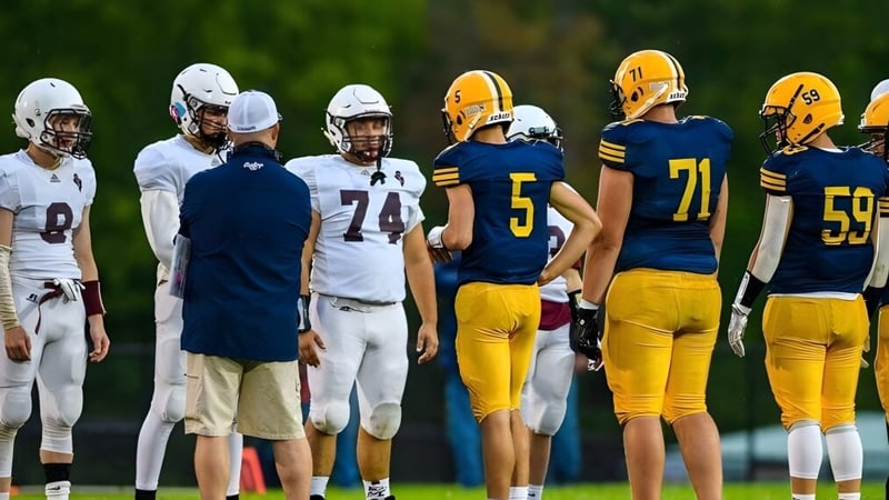 Eine Gruppe von Fußballspielern steht gemeinsam auf einem Spielfeld der Mount Blue High School im Freien.