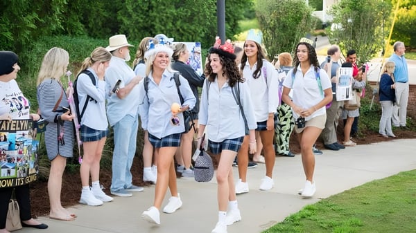 Eine Gruppe Schülerinnen der Mount De Sales Academy geht gemeinsam auf einem von Bäumen umgebenen Weg.