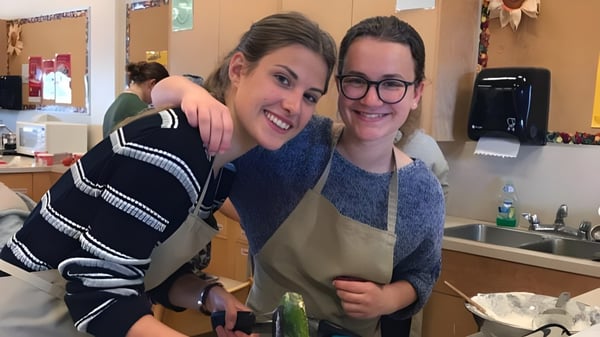Zwei Personen umarmen sich in einem Küchenbereich auf dem Campus der Mount Douglas Secondary School.