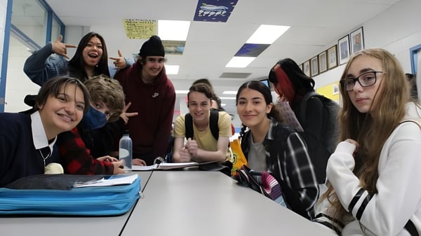 Eine Gruppe von Schülerinnen und Schülern der Mount Elizabeth Middle/Secondary School sitzt um einen Tisch im Klassenraum und arbeitet zusammen.