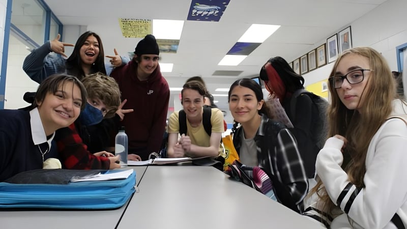 Eine Gruppe von Schülerinnen und Schülern der Mount Elizabeth Middle/Secondary School sitzt um einen Tisch im Klassenraum und arbeitet zusammen.