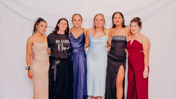 Eine Gruppe von sechs Schülerinnen des Mount Hutt College posiert in formellen Abendkleidern vor weißem Hintergrund.