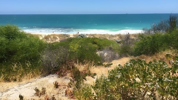 Eine Küstenlandschaft mit Sandstrand und türkisfarbenem Meer unweit von Mount Lawley Senior High School.