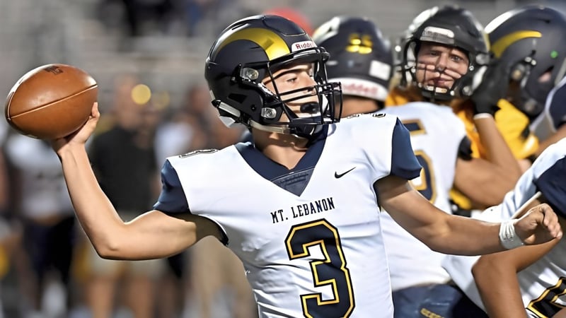 Ein Footballspieler in weißem Trikot mit Nummer 3 hält den Ball beim Nachtspiel der Mount Lebanon High School.