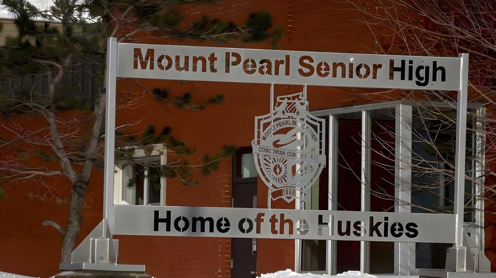 Das Hinweisschild mit dem Schriftzug Home of the Huskies steht vor dem Backsteingebäude der Mount Pearl Senior High School.