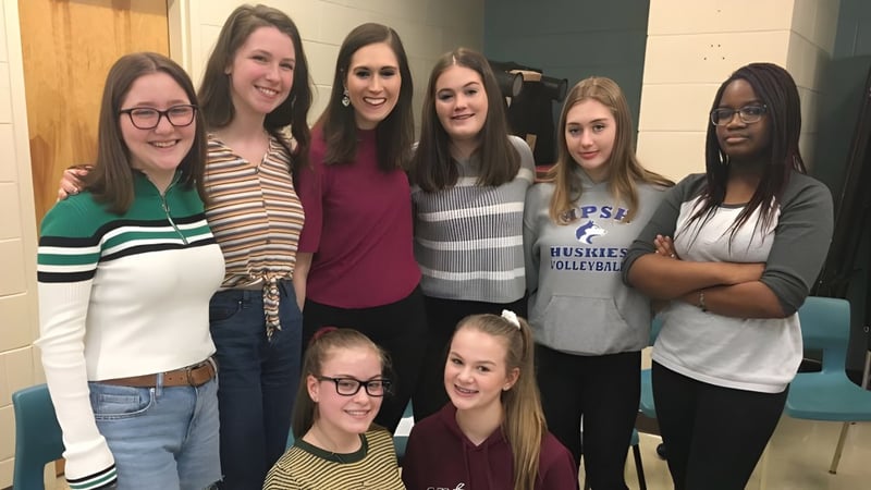 Eine Gruppe Schülerinnen steht und lächelt zusammen auf dem Gelände der Mount Pearl Senior High School.