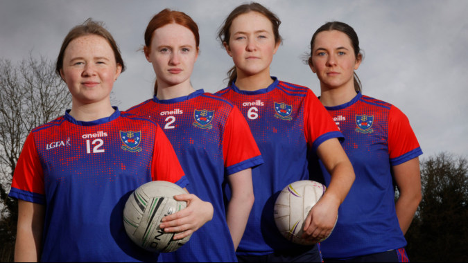 Vier Schülerinnen der Mount Sackville Secondary School in roten und blauen Trikots mit einem Rugbyball im Freien.