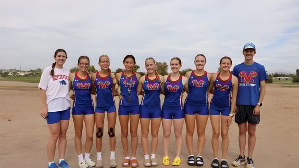 Eine Gruppe junger Athletinnen der Mountain View High School steht auf einem Sportfeld unter bewölktem Himmel.