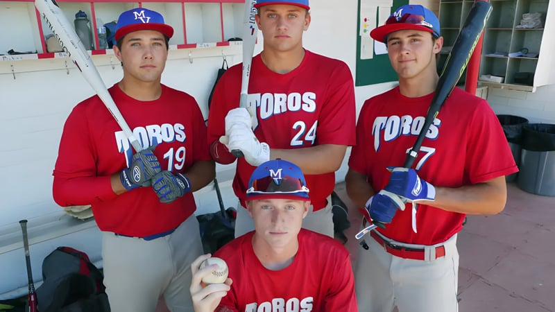 Drei Schüler der Mountain View High School stehen in Baseball-Uniformen im Dugout.