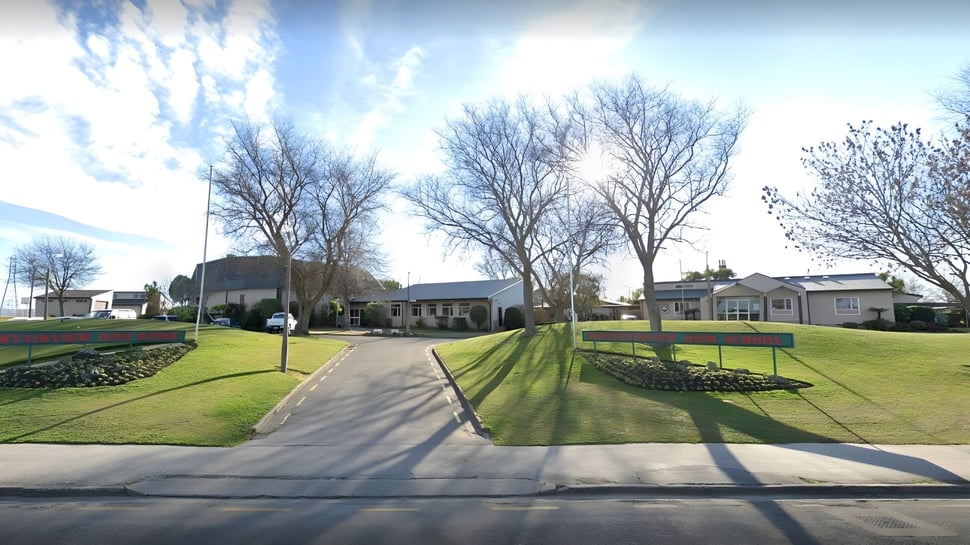 Ein gepflasterter Weg führt durch eine gepflegte Rasenfläche mit kahlen Bäumen auf dem Campus der Mountainview High School.